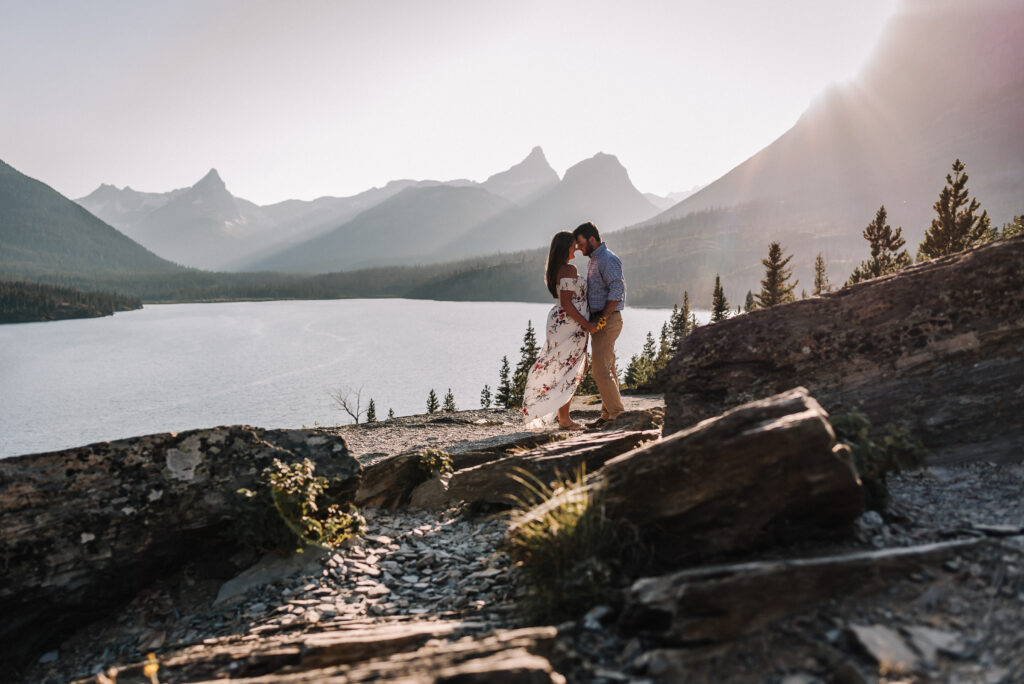 Man and women holding each other in front of mountains in Glacier National Park, Montana