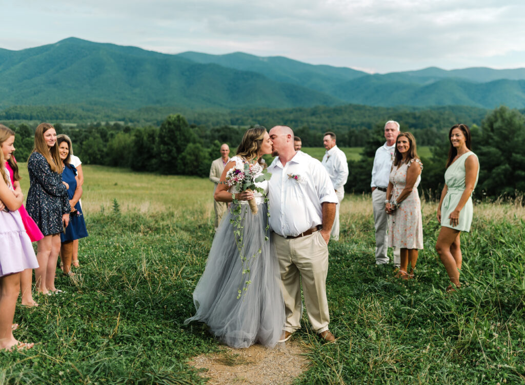 bride and groom kiss as they walk up the aisle created by a few loved ones on their elopement day at Great Smoky Mountains National Park