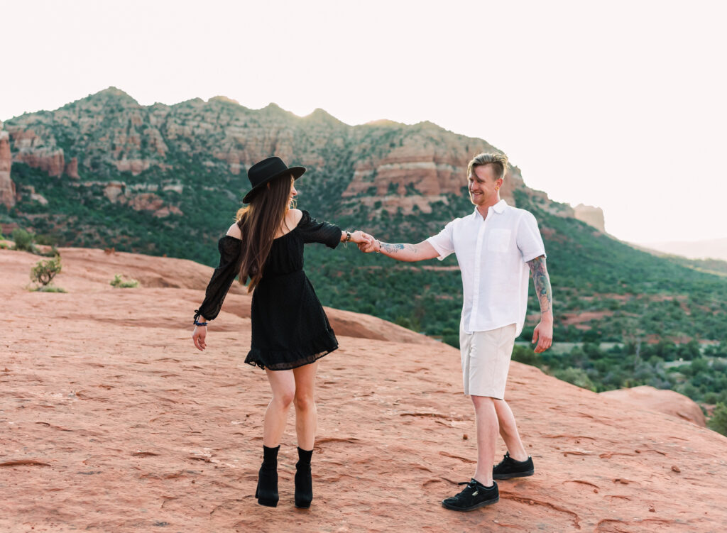 A woman leads her boyfriend around on Bell Rock in Sedona Arizona