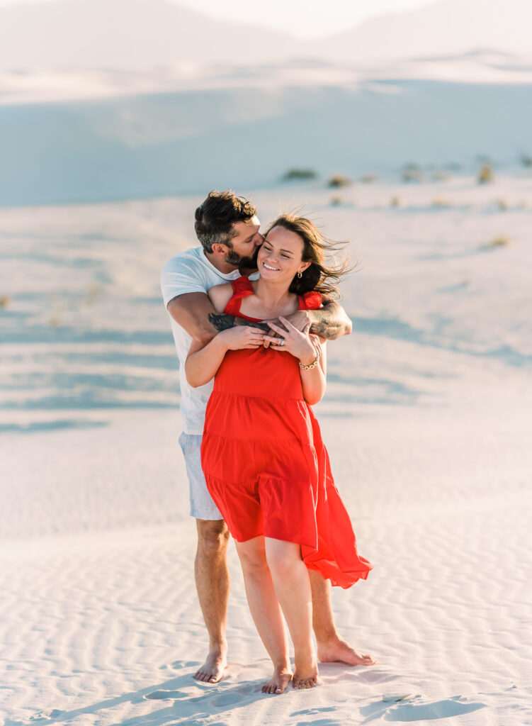 A couple embraces at White Sands National Park during their couple adventure session