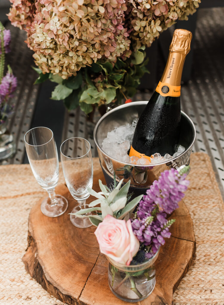 A proposal site set up with champagne and champagne flutes and flowers