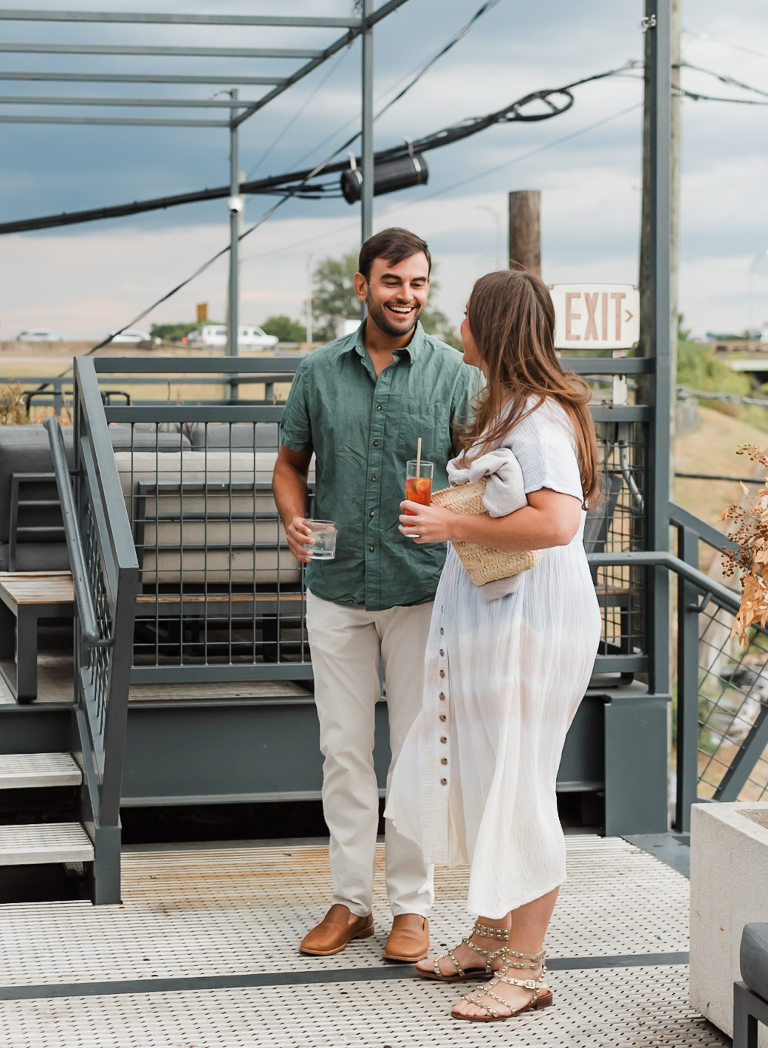 A man and woman walk up to the proposal site the man has planned. The woman is surprised and smiling