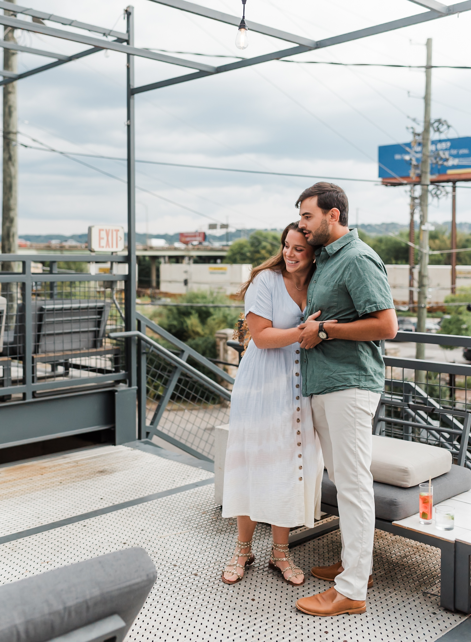 A man and woman walk up to the proposal site the man has planned. The woman is surprised and smiling