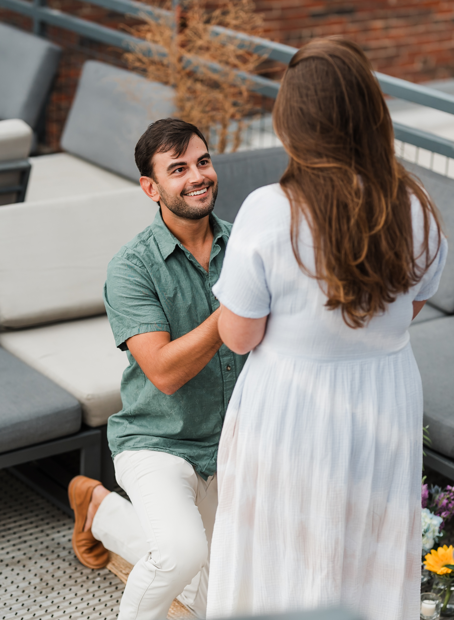 A man is down on one knee proposing to his girlfriend