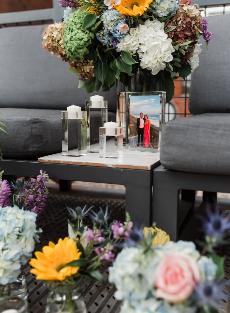 A proposal site set up with flowers in vases and a printed photograph of the couple.