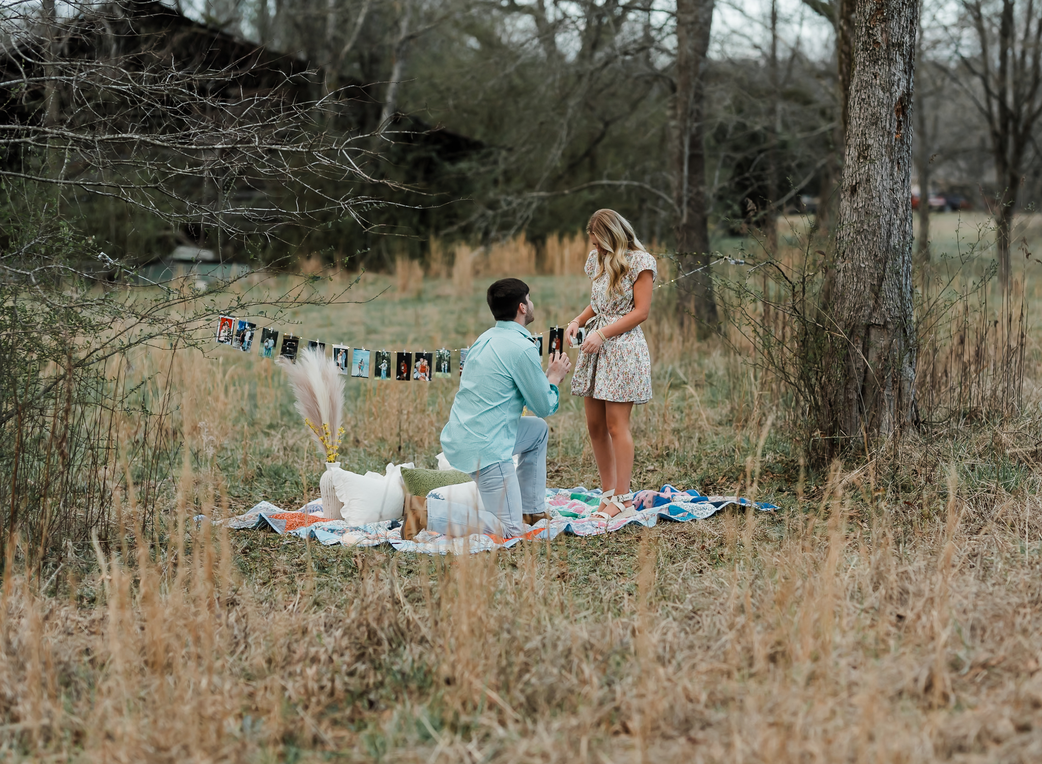 A man is down on one knee proposing to his girlfriend while she is looking at him.