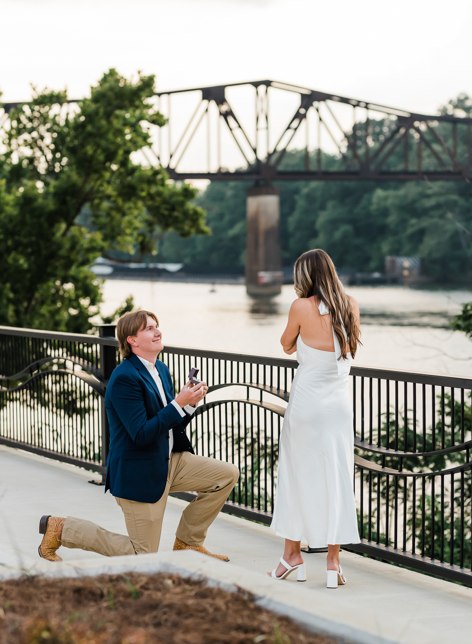 A man is down on one knee proposing to his girlfriend.