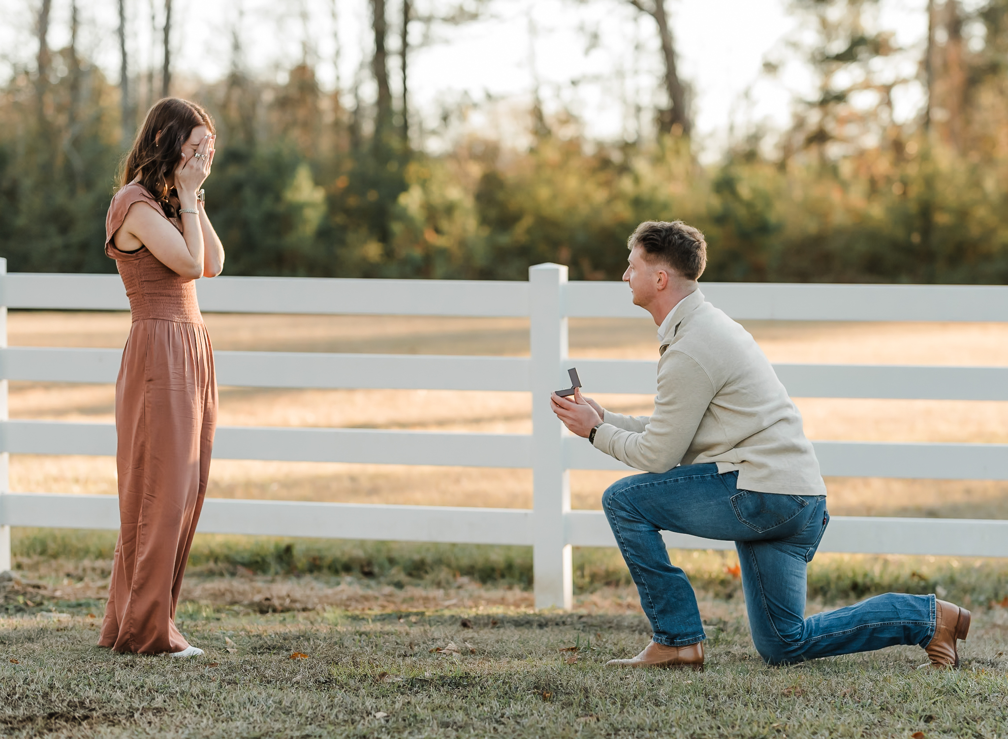 A man is down on one knee proposing to his girlfriend.