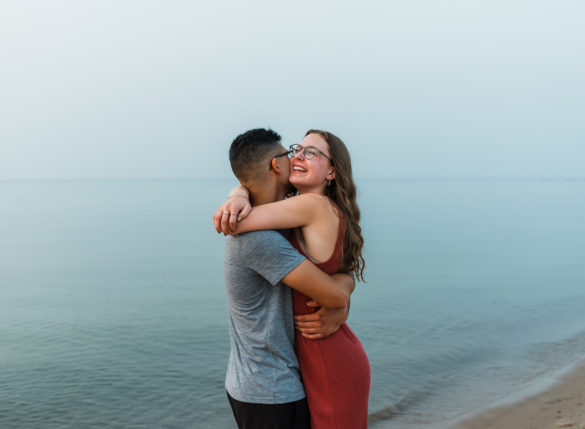 A runs into each others arms during their adventure session at Indiana Dunes National Park on Lake Michigan