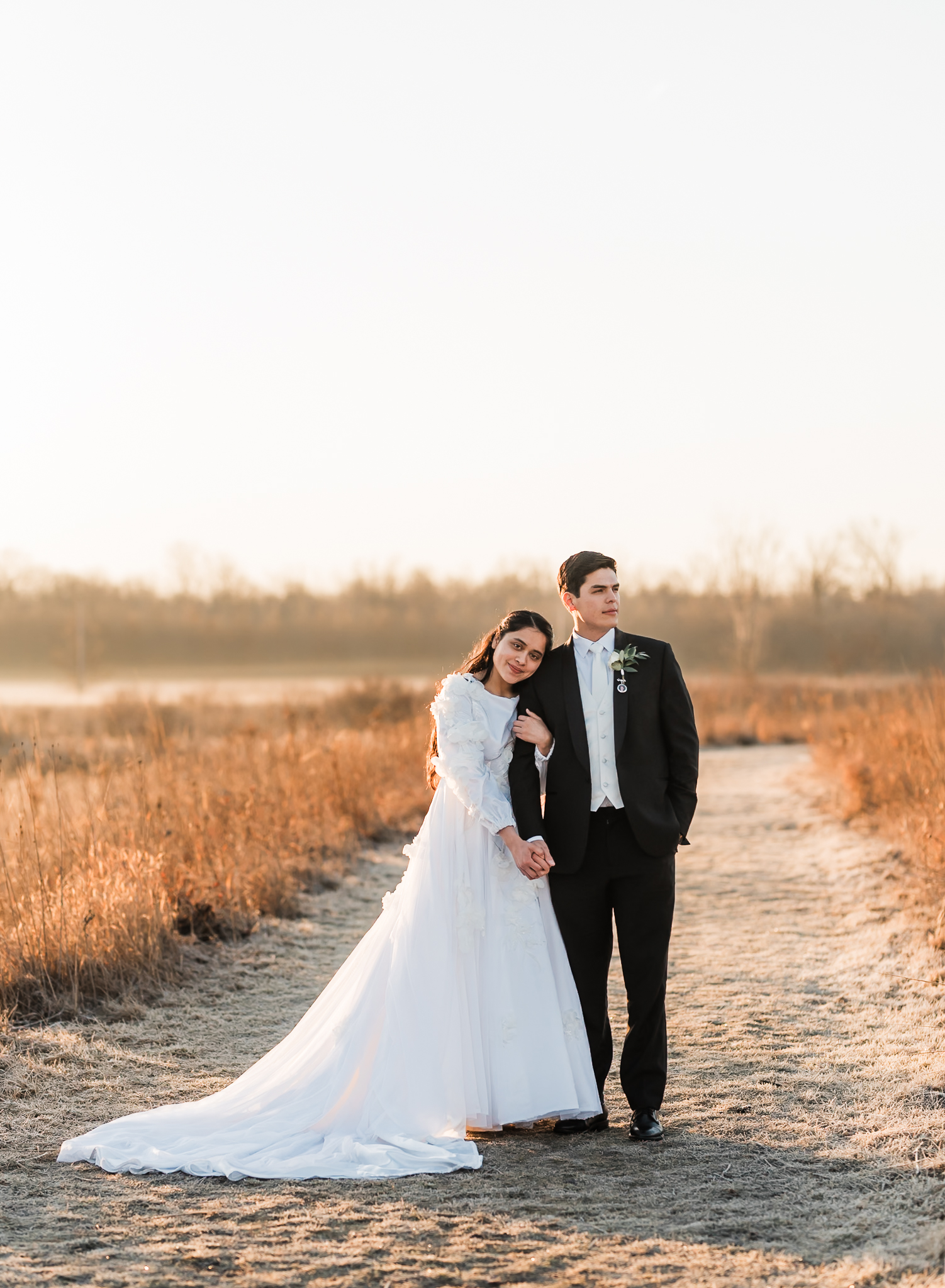 Sunrise elopement with a couple standing in golden hour light on a wide open plain.