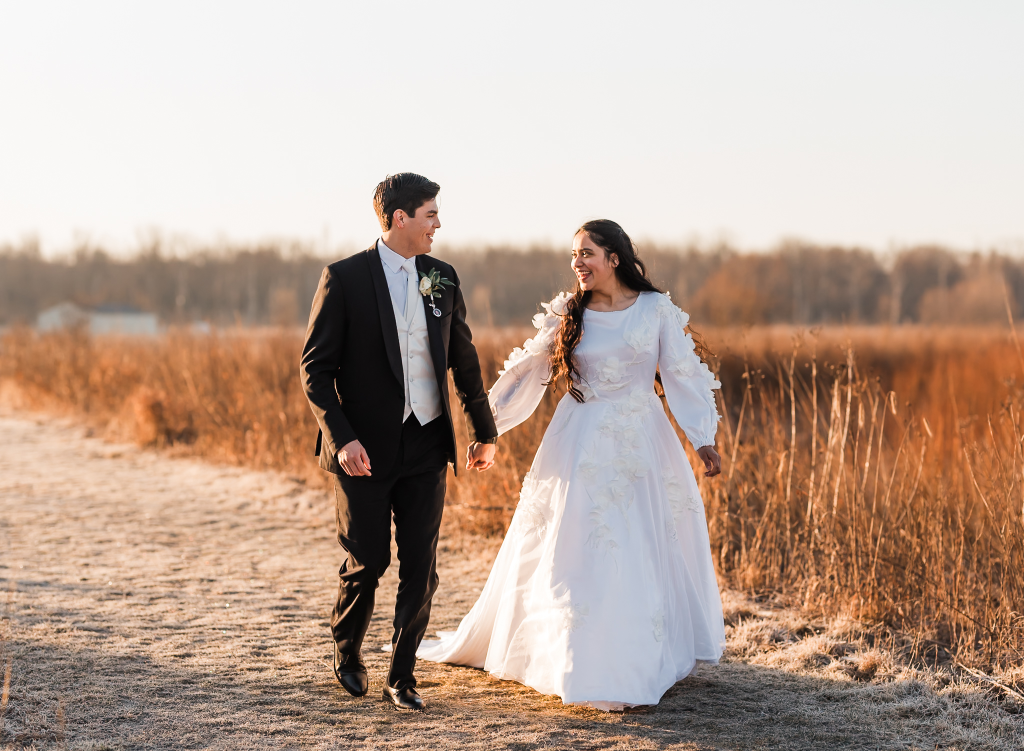 Sunrise elopement with a couple running together in golden hour light on a wide open plain.