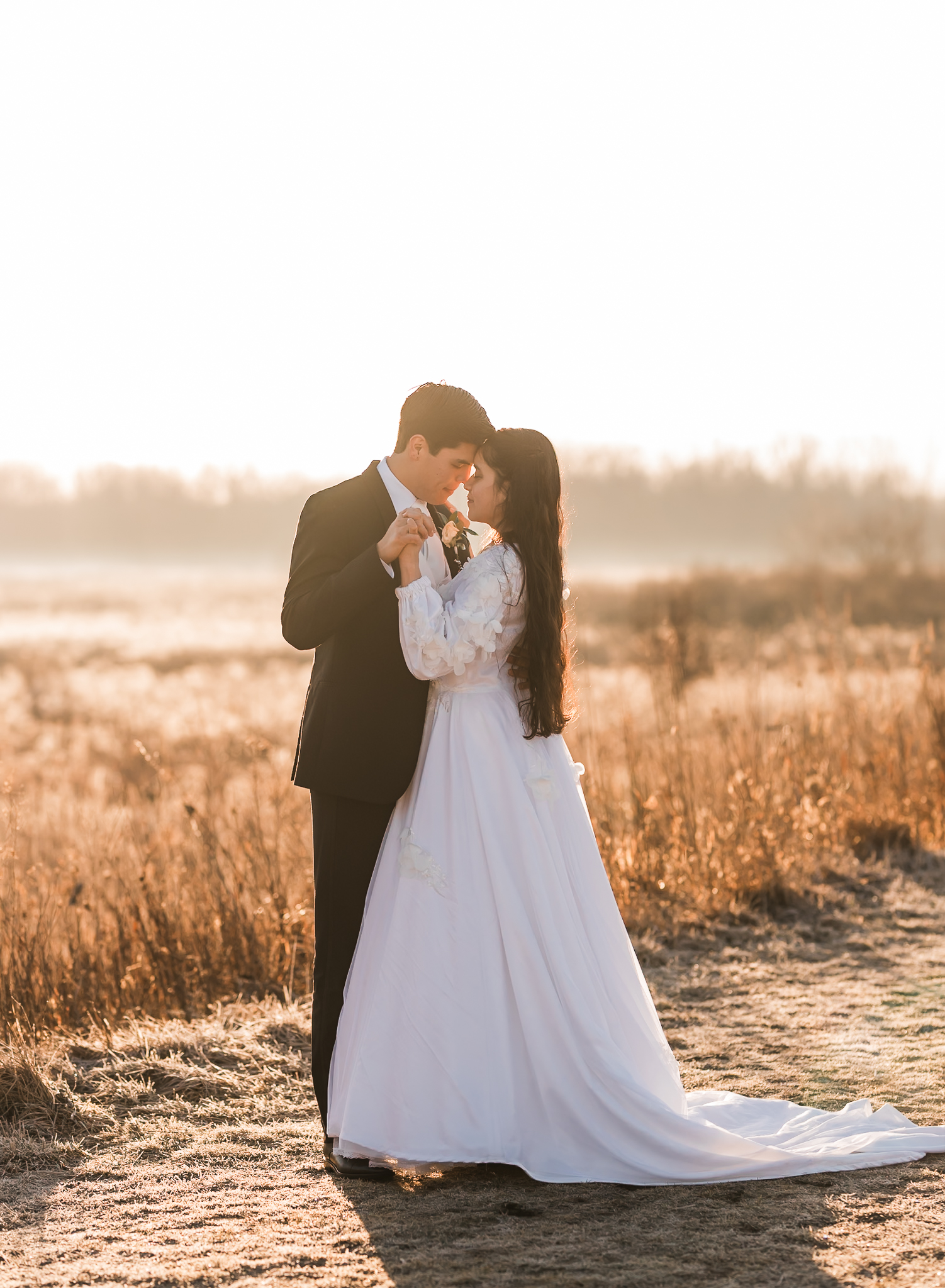Sunrise elopement with a couple dancing in golden hour light on a wide open plain.