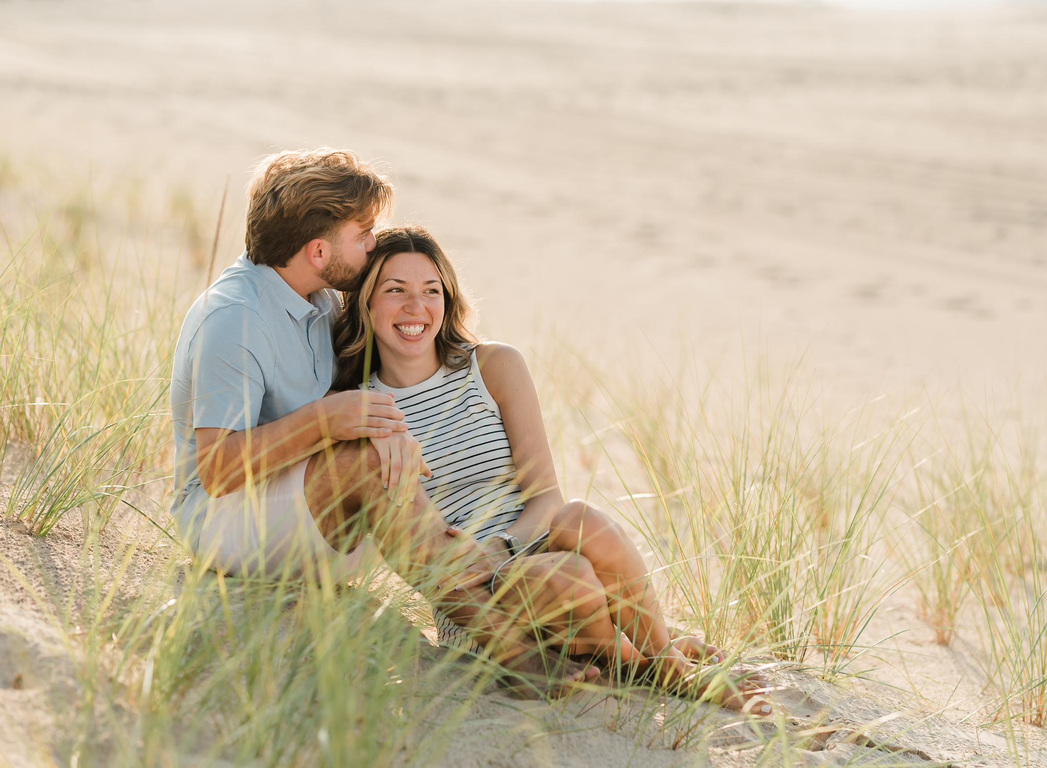A sitting in the sand during their adventure session at Indiana Dunes National Park on Lake Michigan