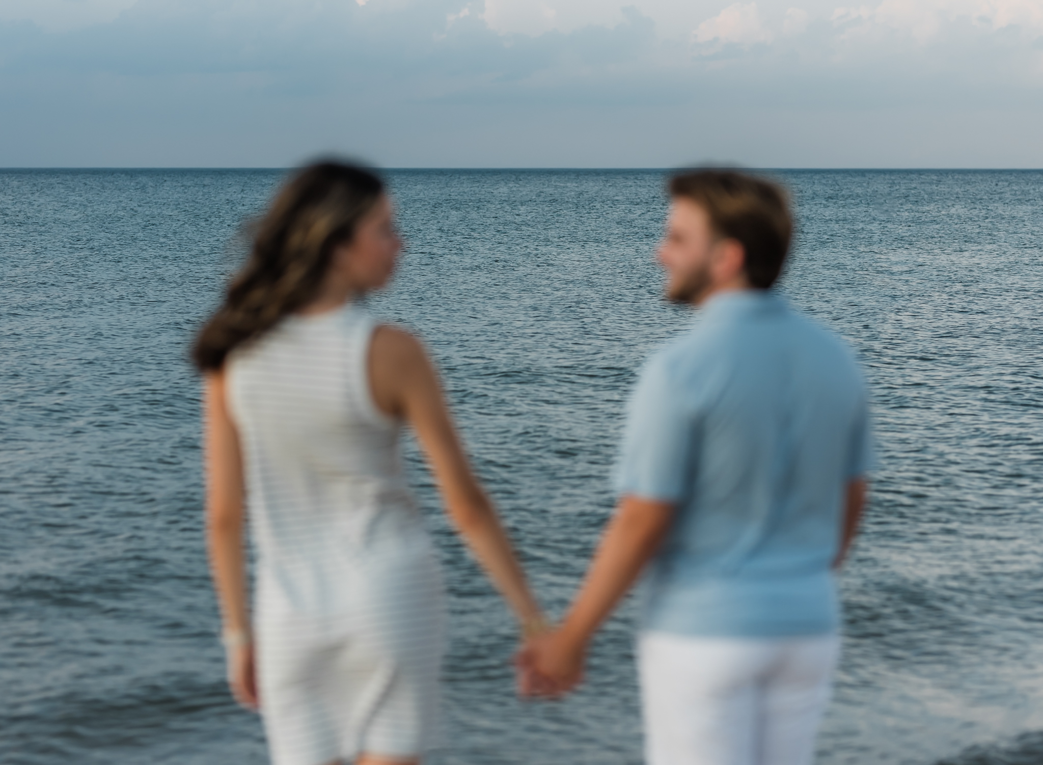 A couple standing and holding hands during their adventure session at Indiana Dunes National Park on Lake Michigan