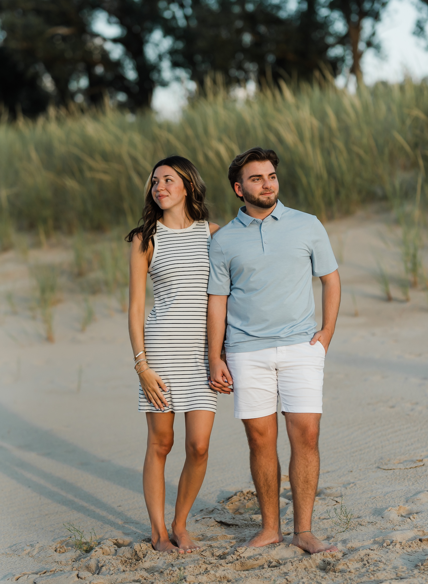 A couple standing together in the sand during their adventure session at Indiana Dunes National Park on Lake Michigan