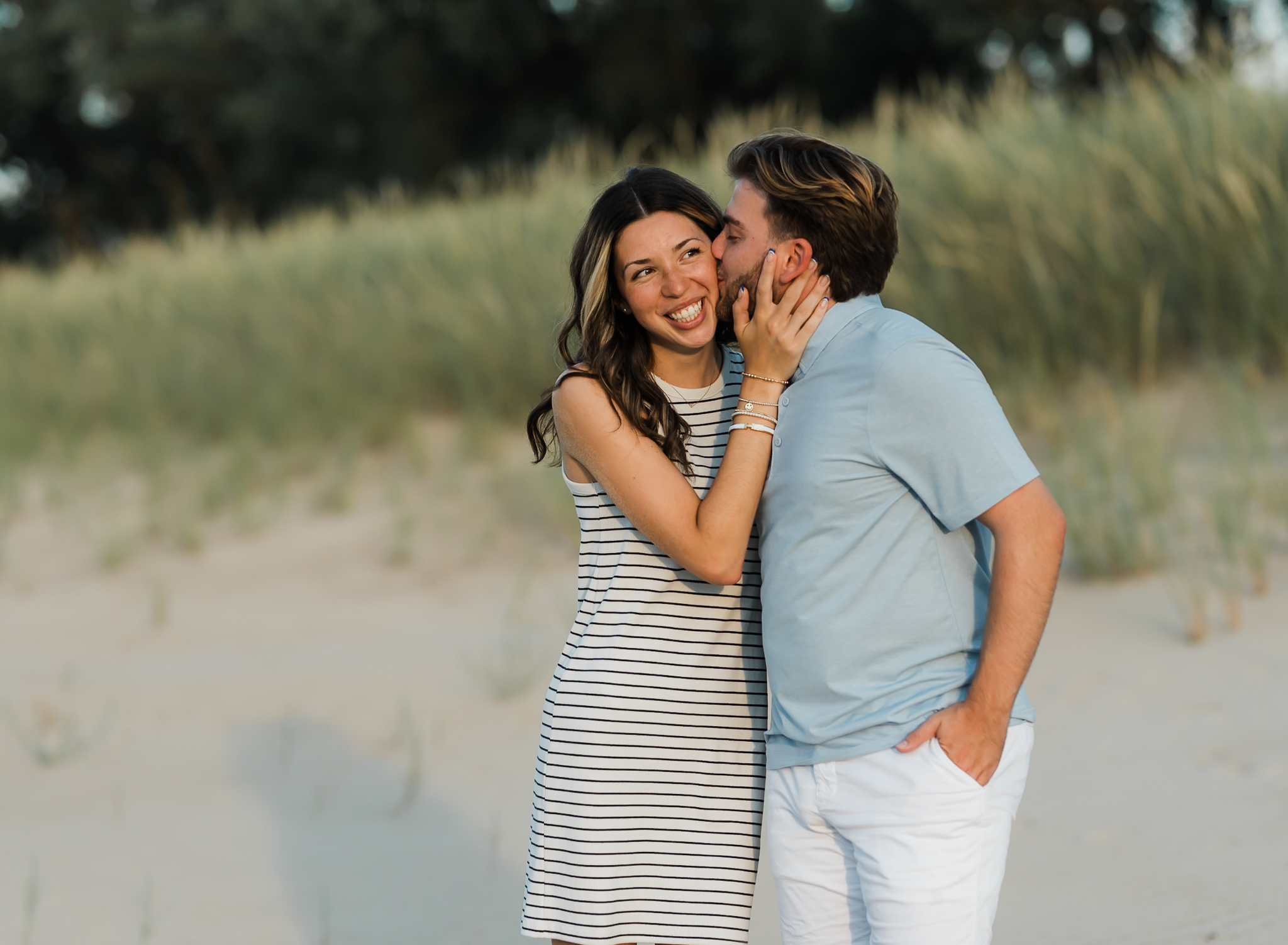 A couple kissing during their adventure session at Indiana Dunes National Park on Lake Michigan