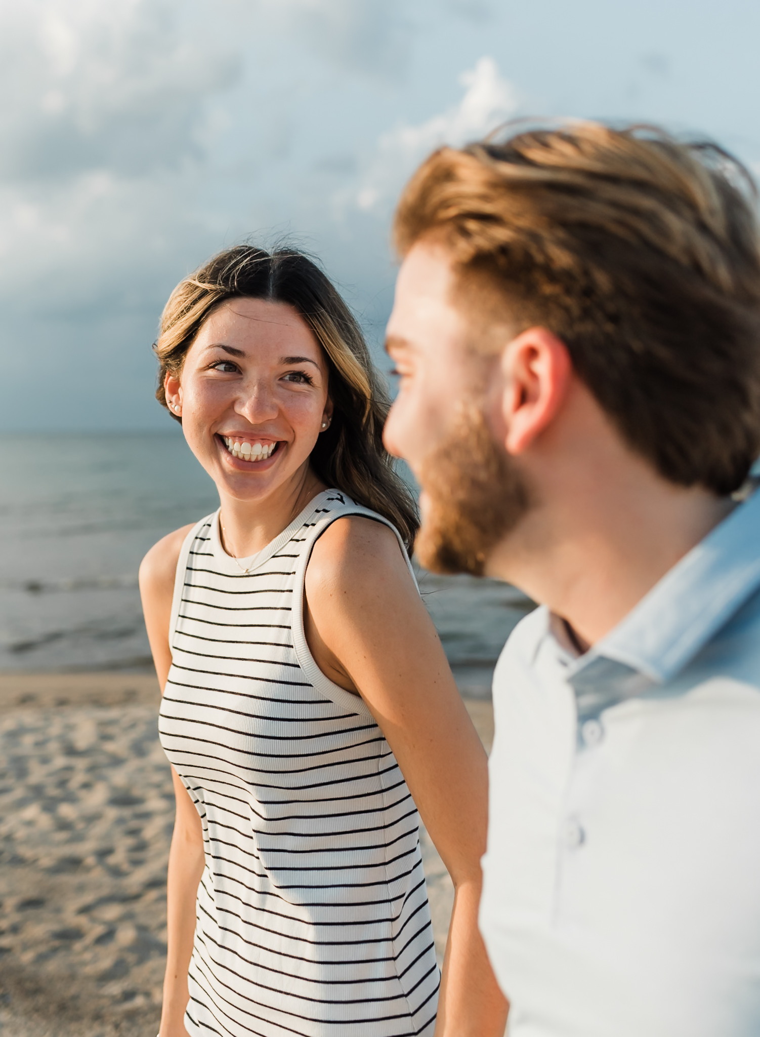 A couple walking hand in hand during their adventure session at Indiana Dunes National Park on Lake Michigan
