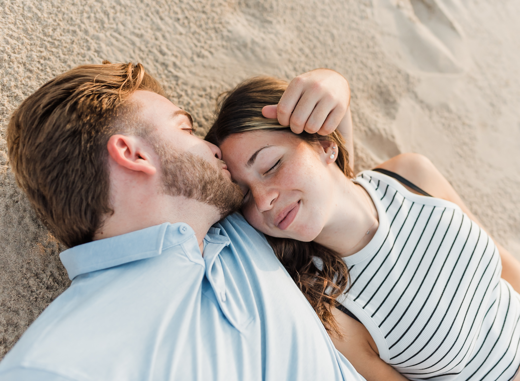 A laying in the sand during their adventure session at Indiana Dunes National Park on Lake Michigan