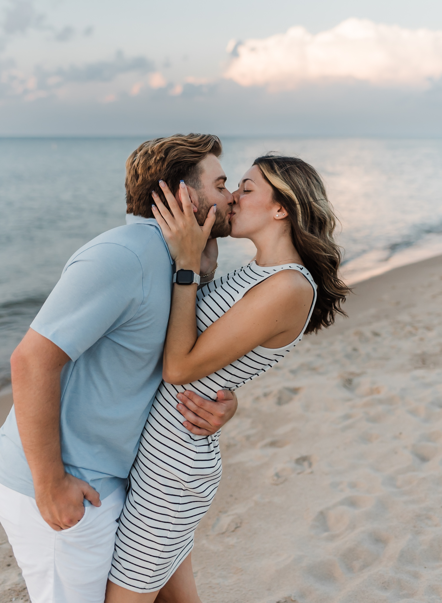A couple kissing during their adventure session at Indiana Dunes National Park on Lake Michigan