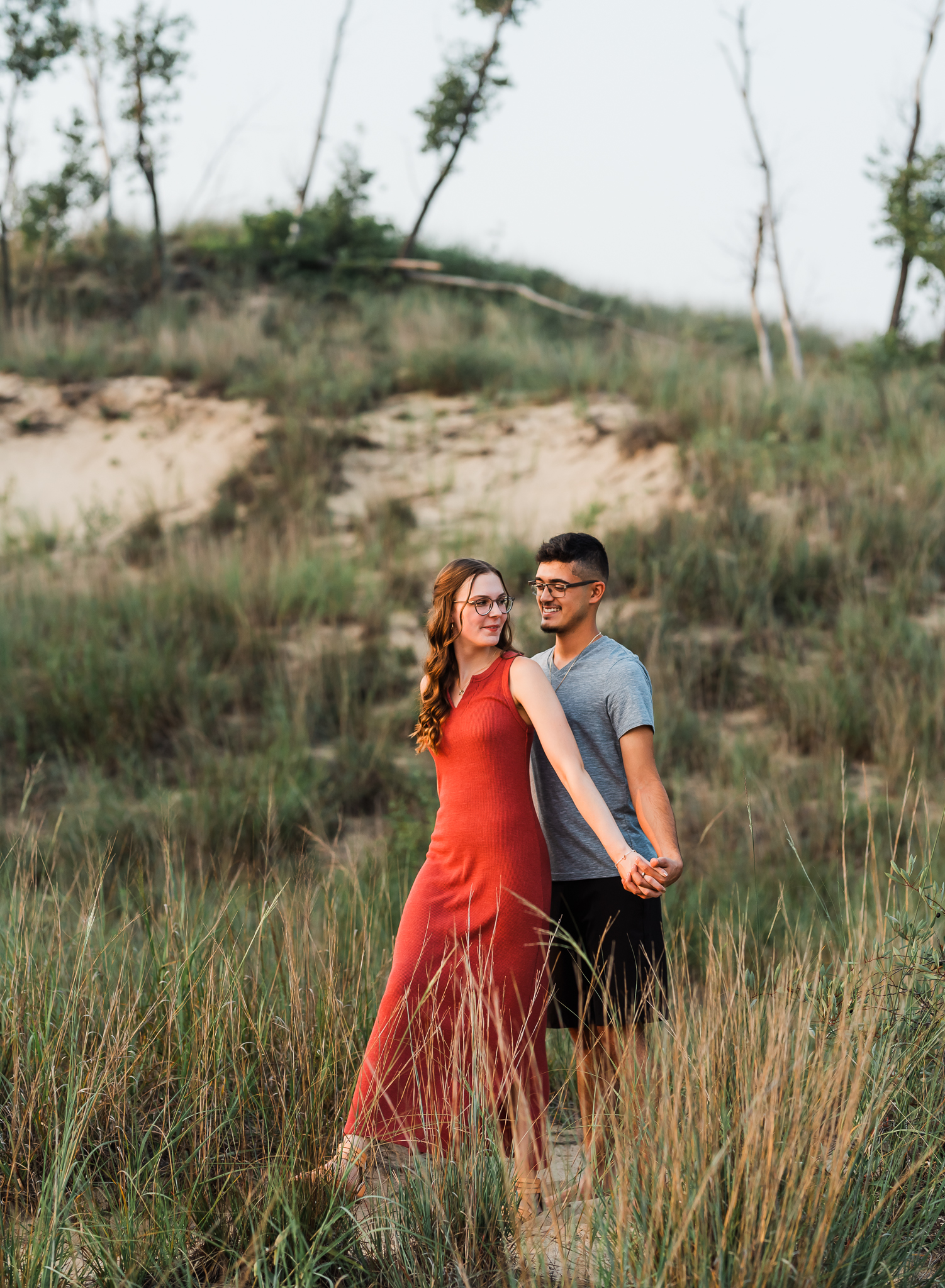 A couple embraces during their adventure session at Indiana Dunes National Park on Lake Michigan