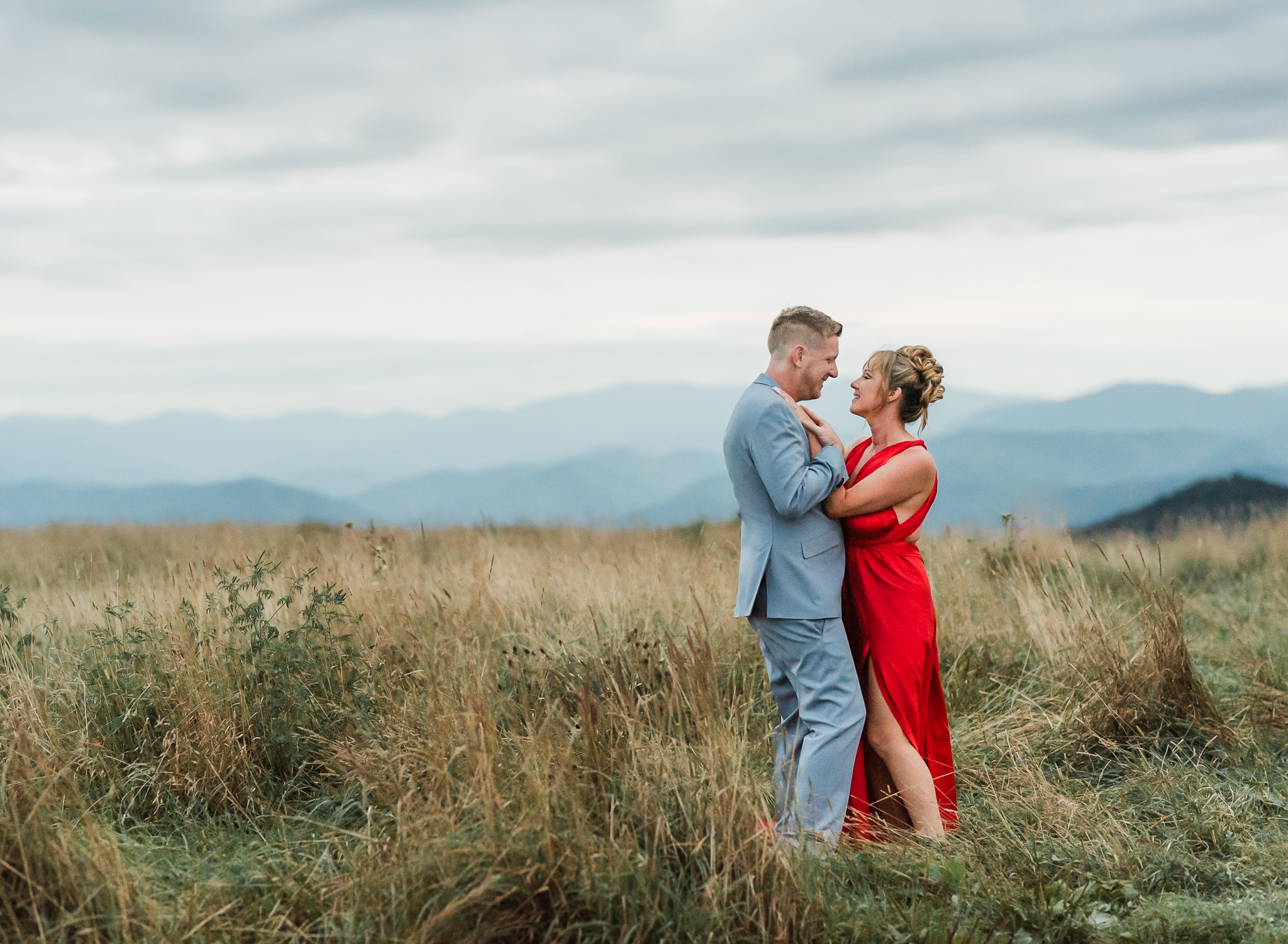 A woman and man embrace at their engagement session in Max Patch North Carolina.