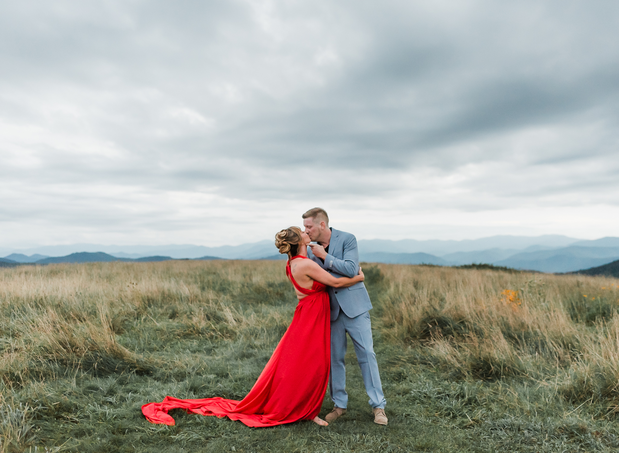A woman and man embrace at their engagement session in Max Patch North Carolina.