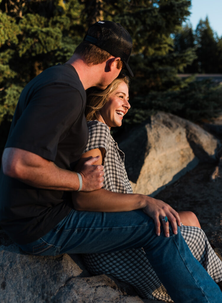 A couple sitting together at an overlook at their Crater Lake National Park engagement session.