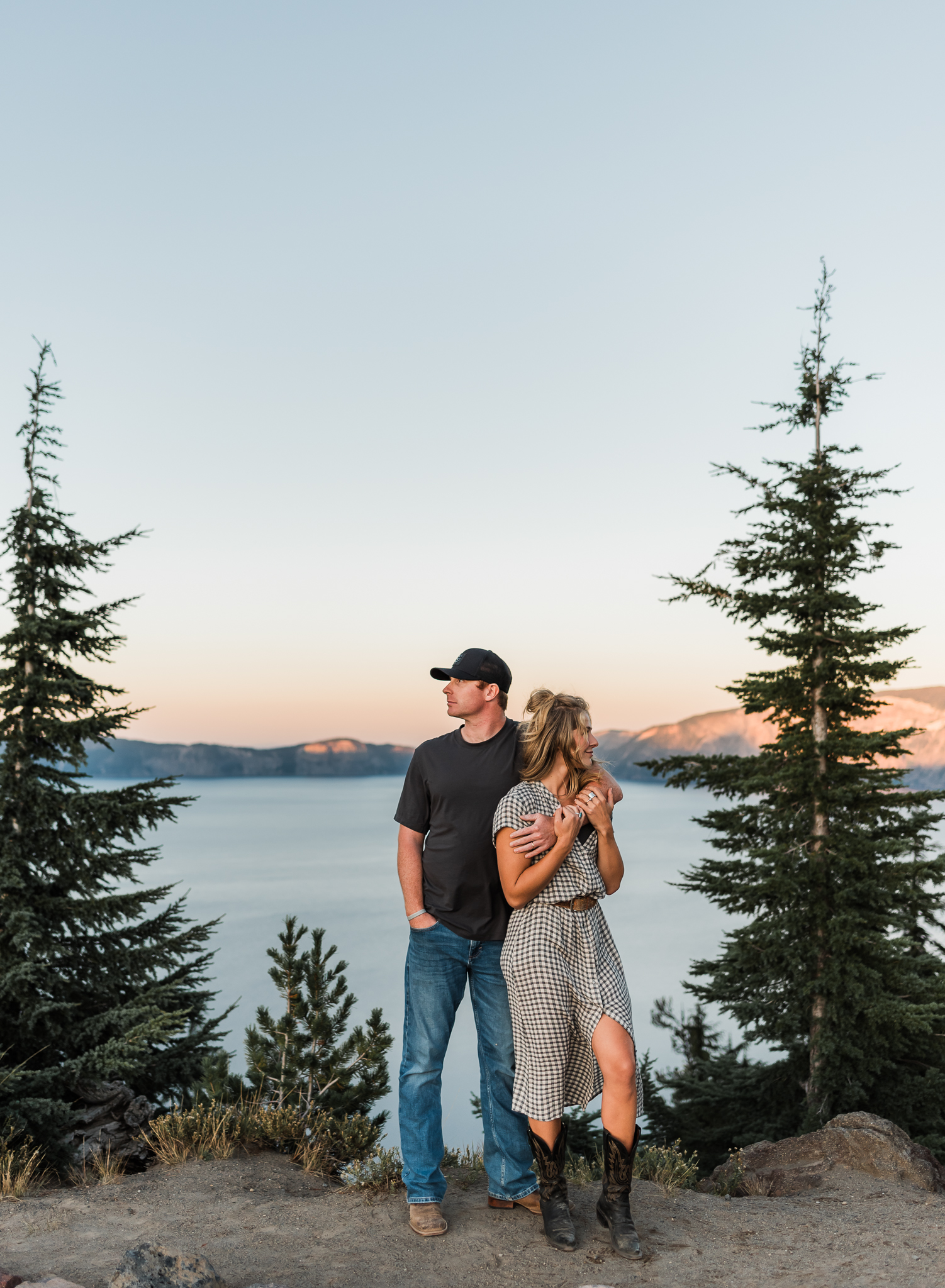 A couple standing together at an overlook at their Crater Lake National Park engagement session