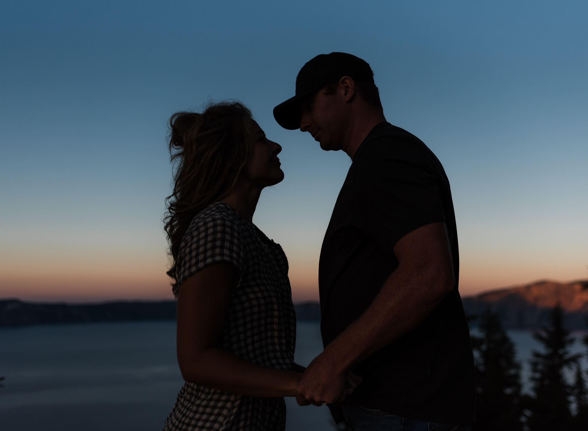 A sillhouette of a couple at sunset at their Crater Lake National Park engagement Session.