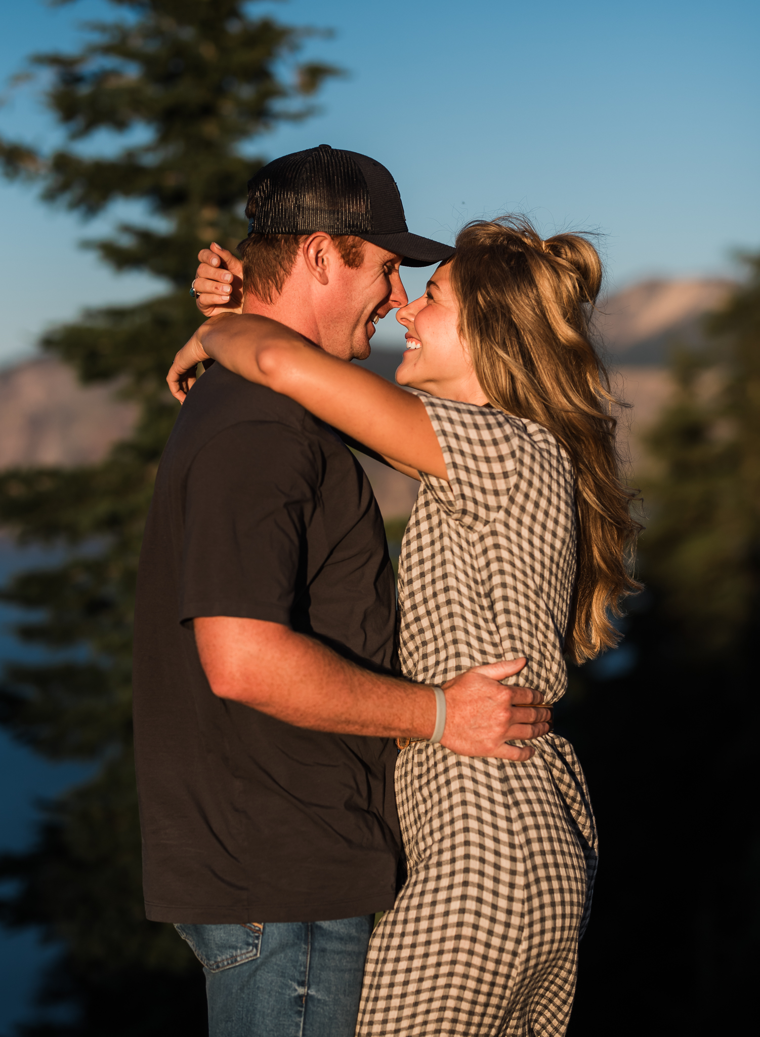 A couple embracing at an overlook at their Crater Lake National Park engagement session.