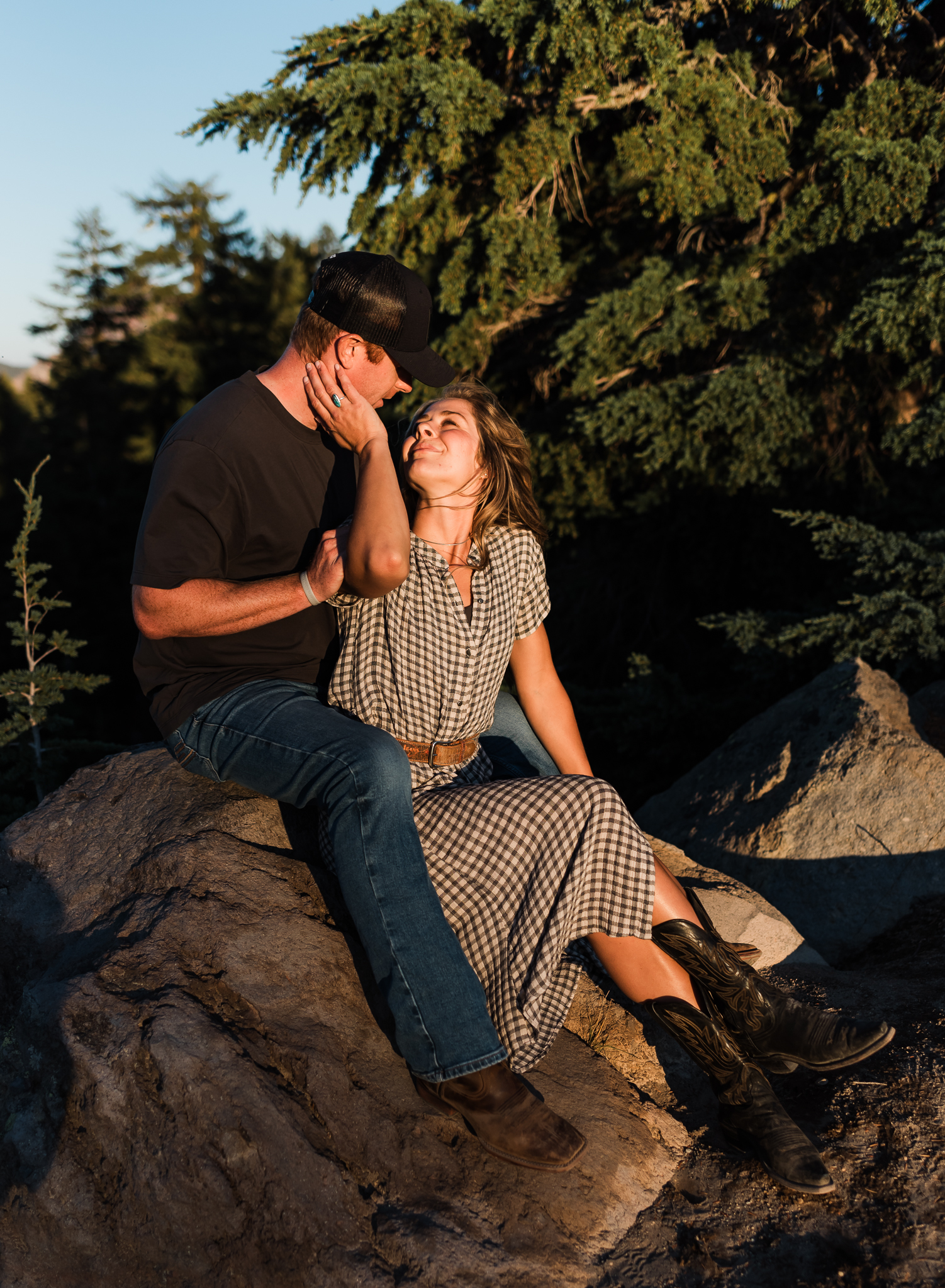 A couple sitting together at an overlook at their Crater Lake National Park engagement session.