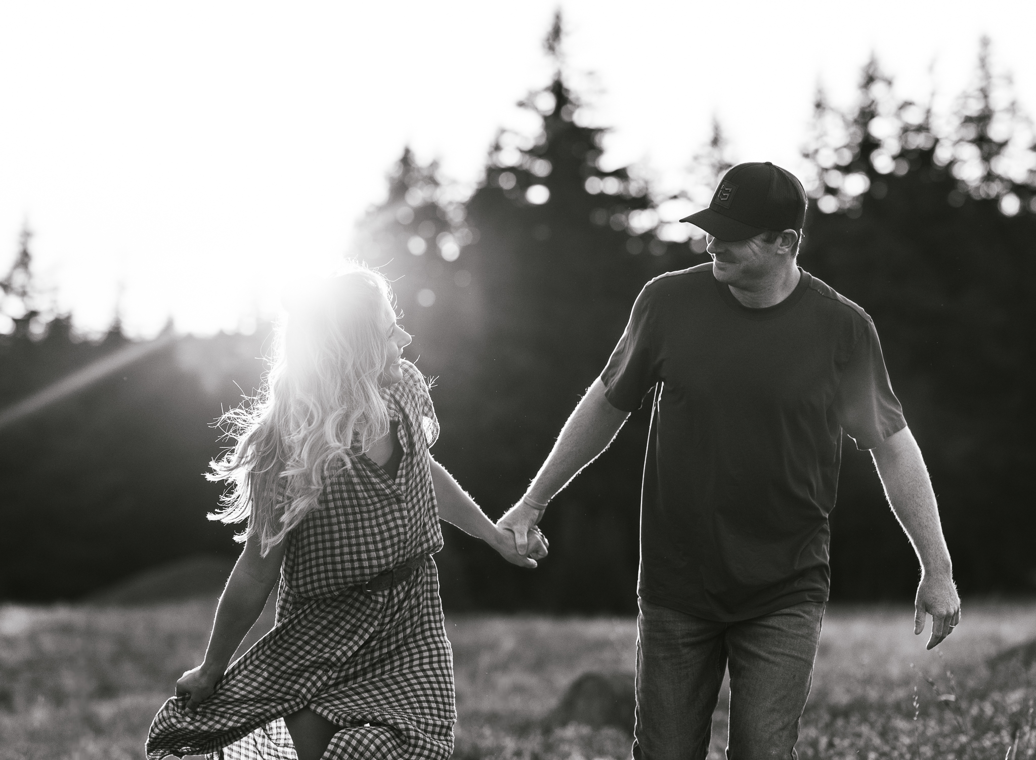 A couple running through a field at their Crater Lake National Park engagement session. 