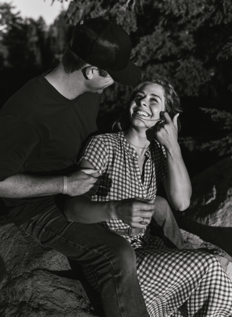 A couple sitting together at an overlook at their Crater Lake National Park engagement session.
