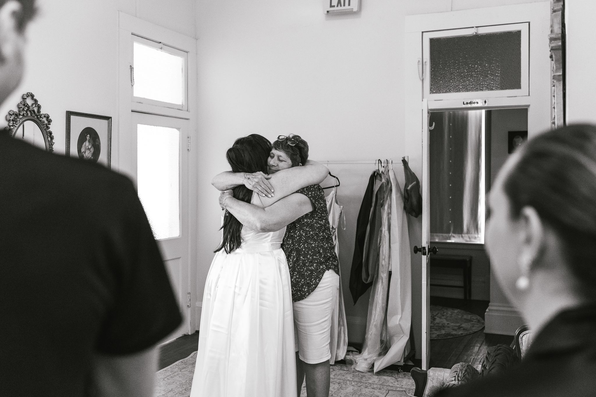 A bride and grandmother hug at intimate wedding.