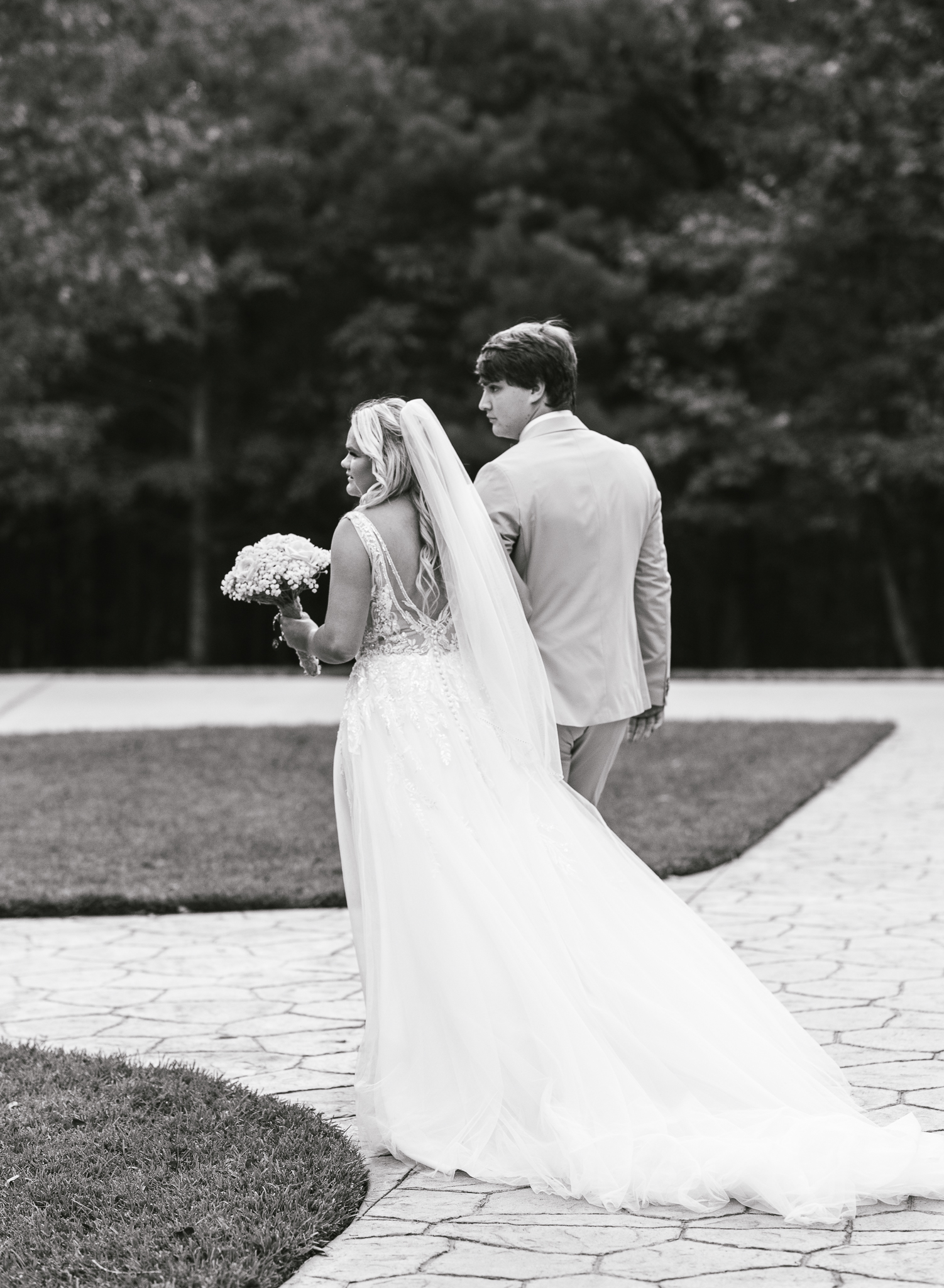 A bride and groom walk hand in hand at their intimate wedding. 