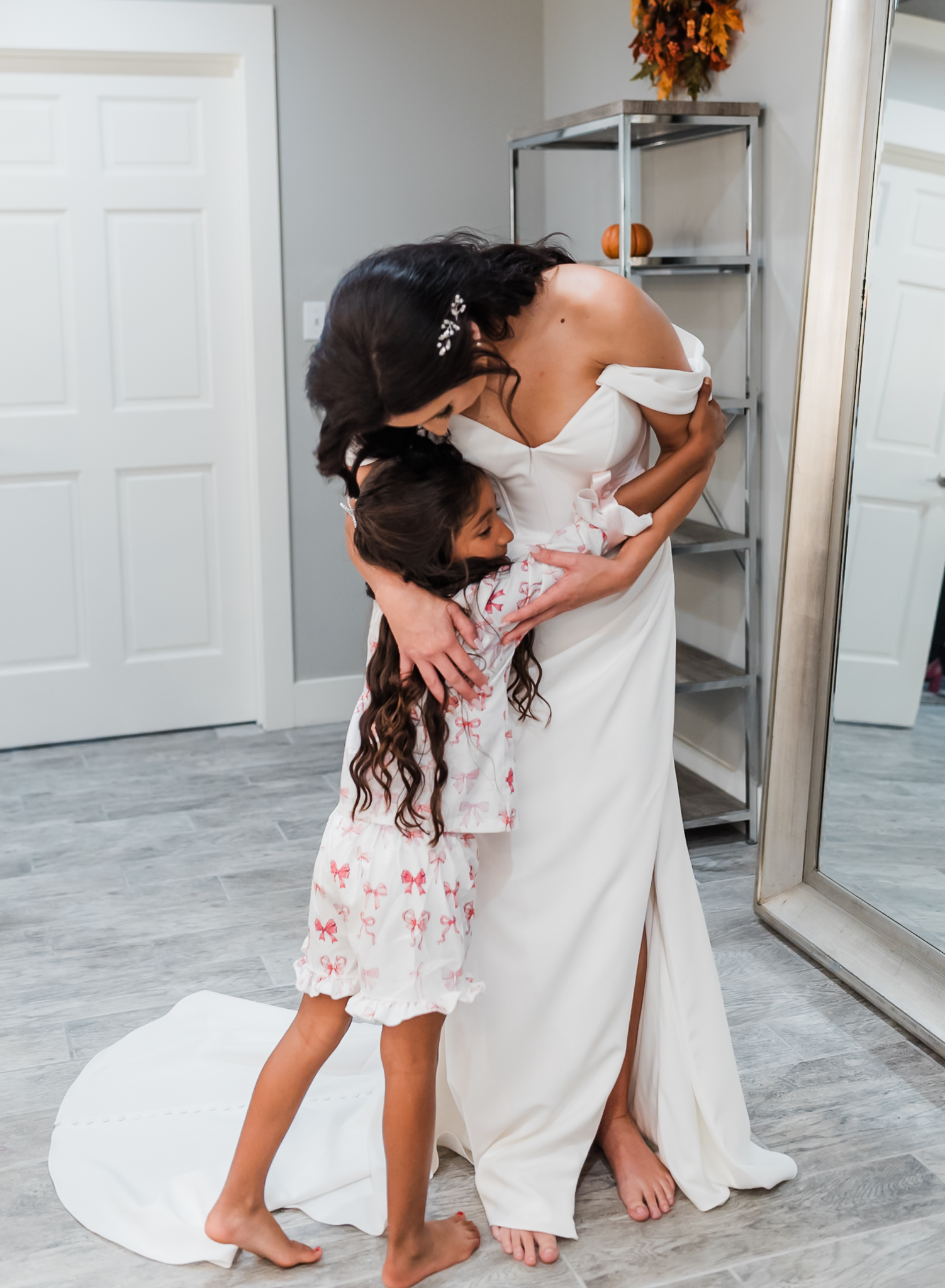 A bride and her daughter hug at her intimate wedding.