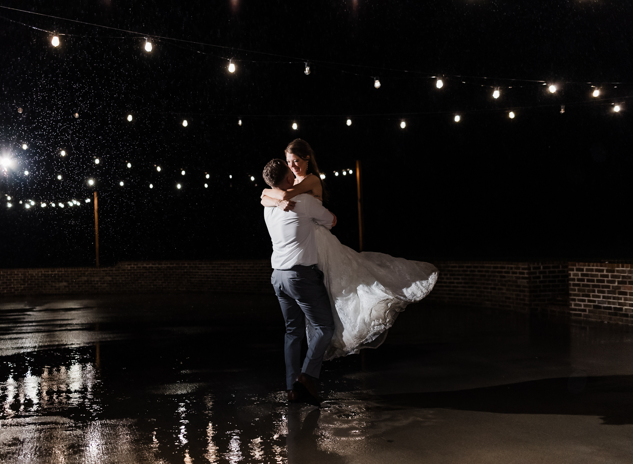 a bride and groom dance in the rain at their intimate wedding 