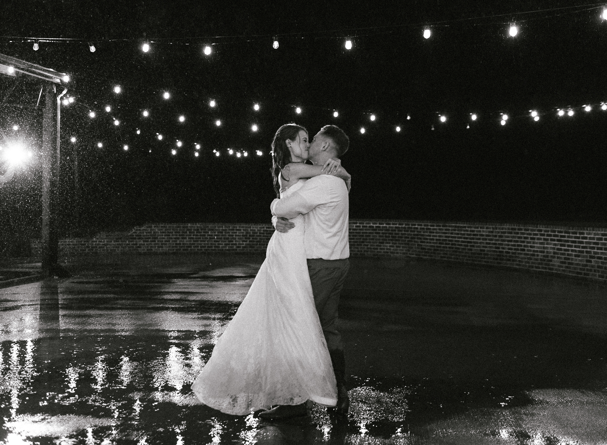 a bride and groom dance in the rain at their intimate wedding 
