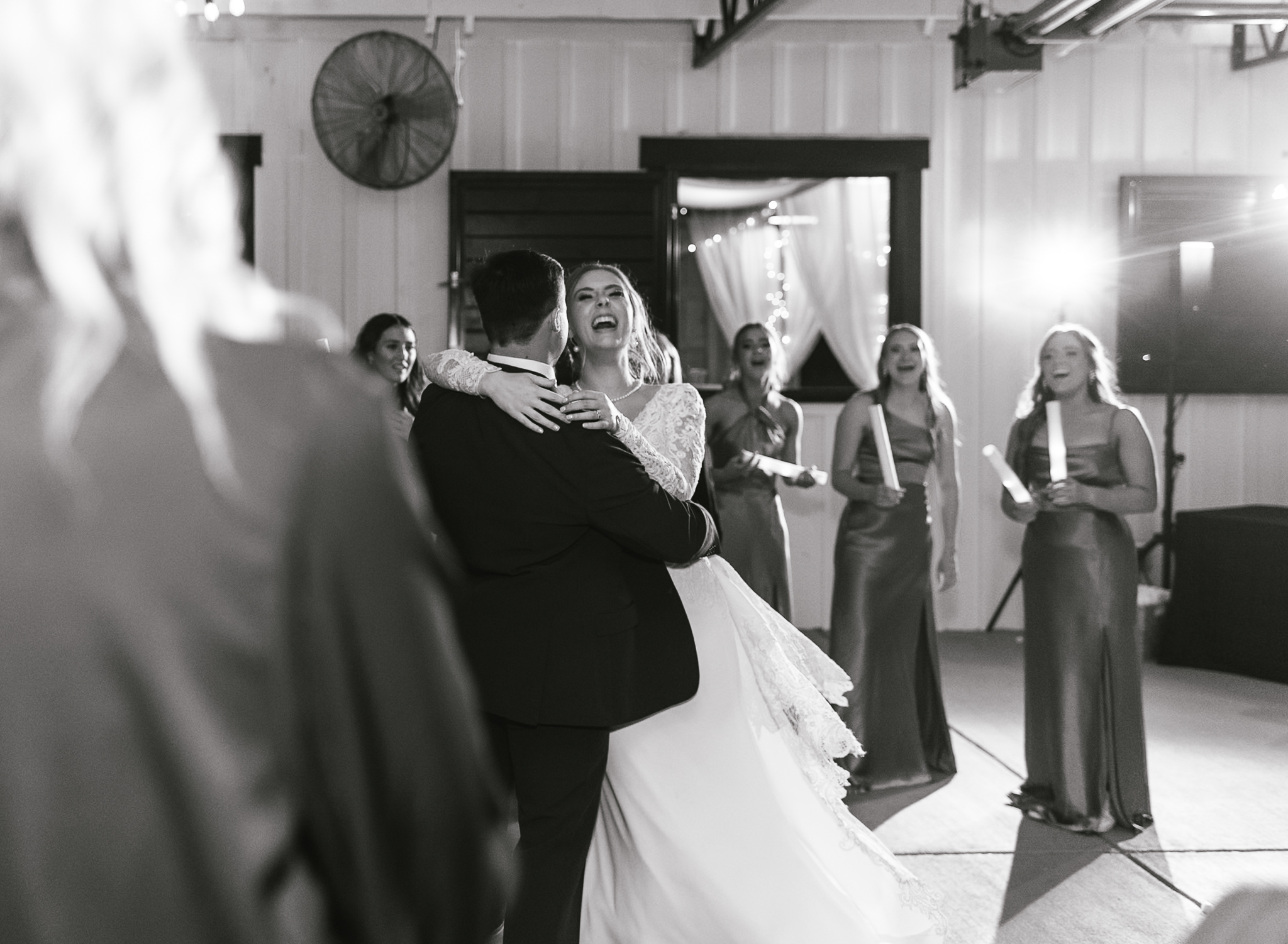A bride dances with her groom and she is laughing at their intimate wedding reception